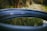 A small blue water tank of 250 liters placed in a garden setting.