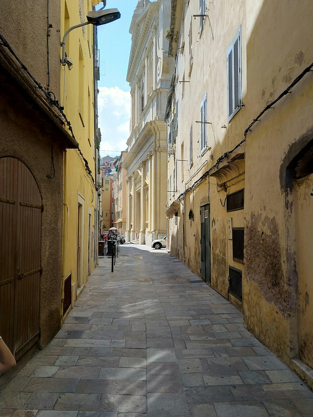 gray concrete road in between buildings