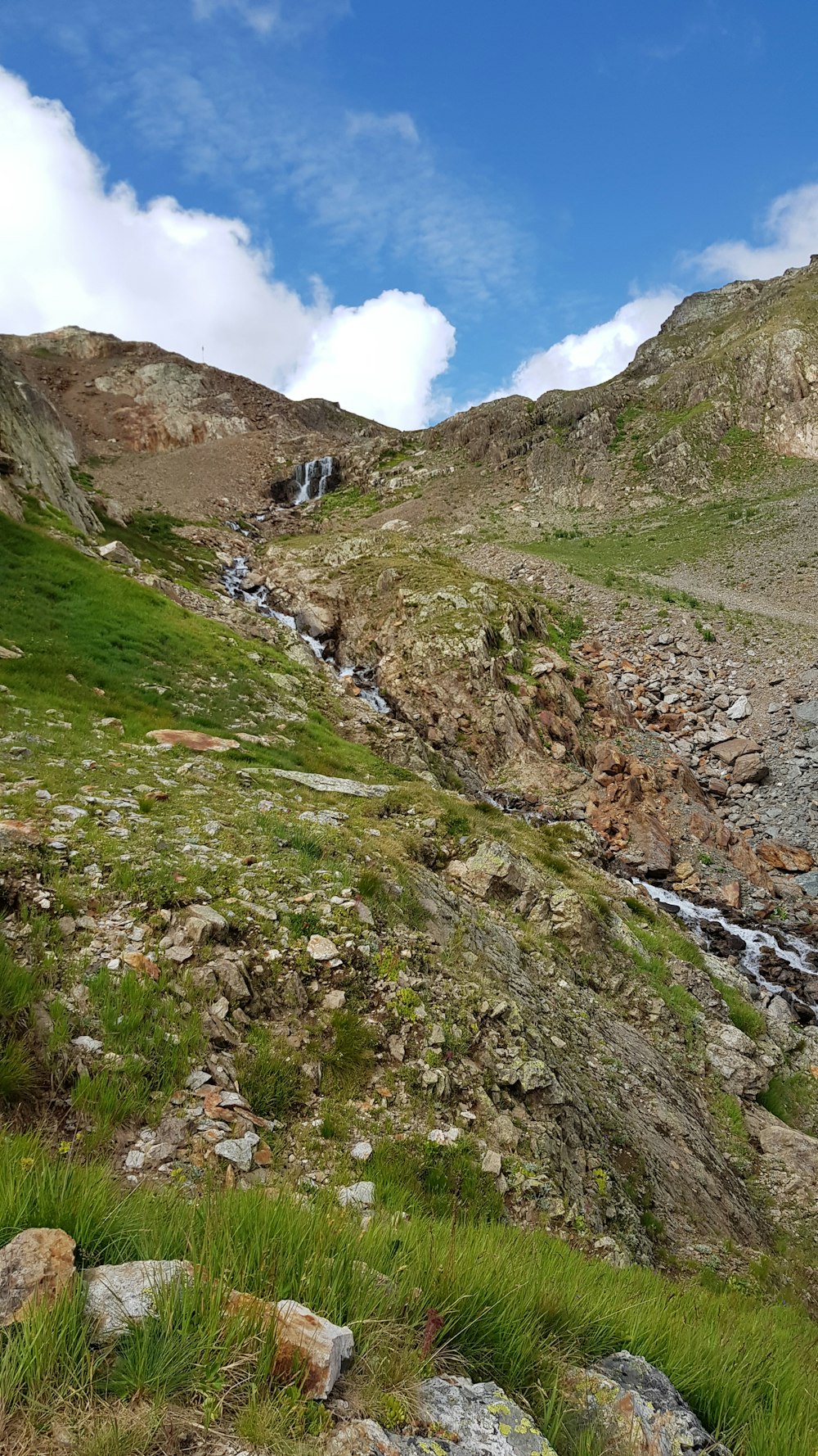 a rocky hillside with a stream running through it