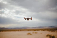 Drone flying over a vast desert landscape conducting aerial mapping.