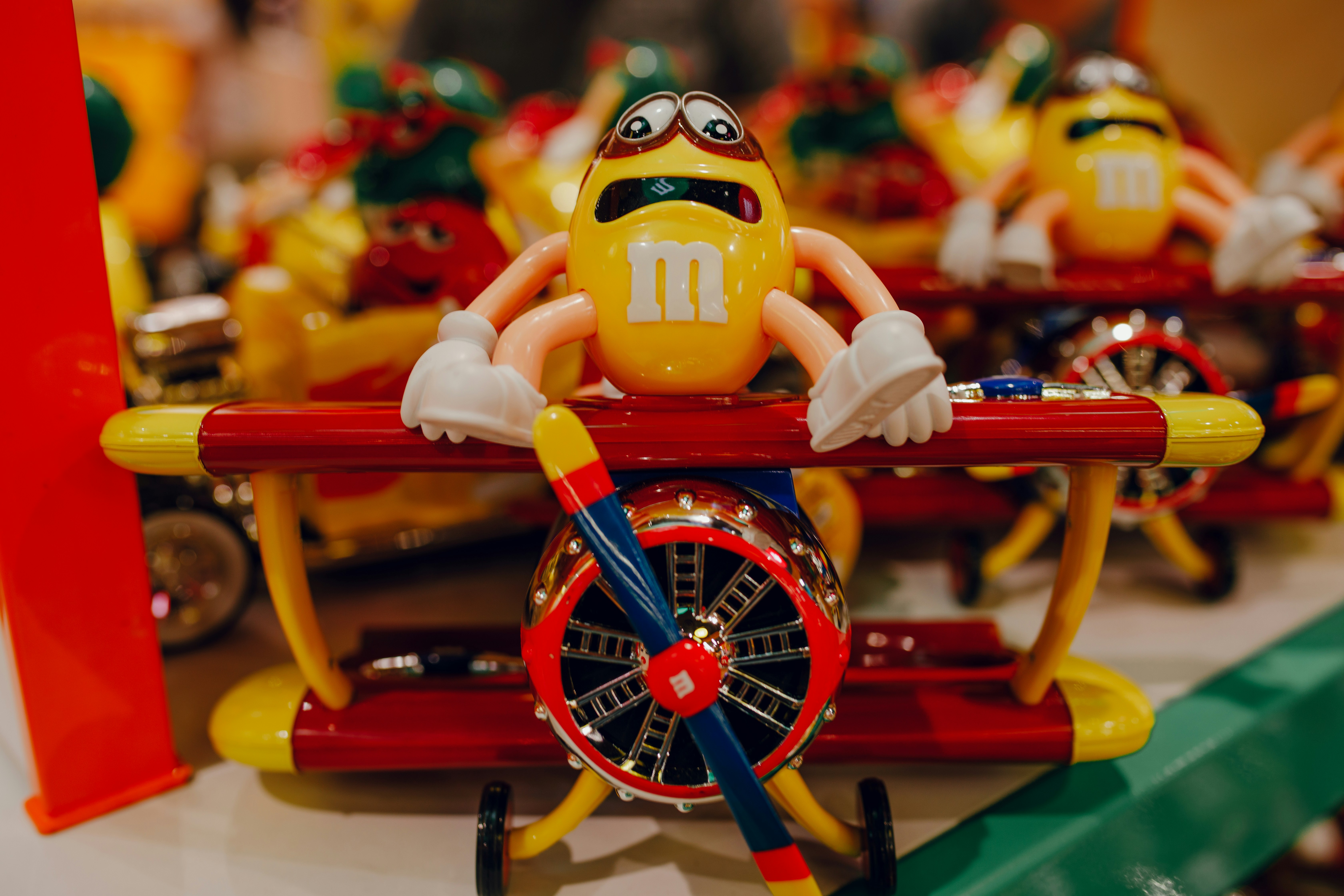 黄色と赤のM&Mのキャラクター乗馬飛行機のおもちゃの写真 – Unsplashの 