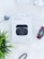 A box labeled 'Latitude Series' containing wireless earbuds is positioned in the center on a light background. An additional earbud, a smart watch with colorful display, a set of silver over-ear headphones and a green plant are arranged around it.