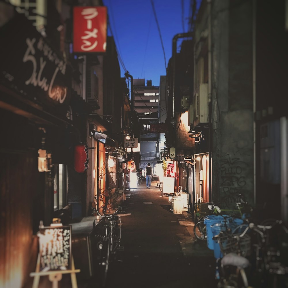 man stands on alley between buildings