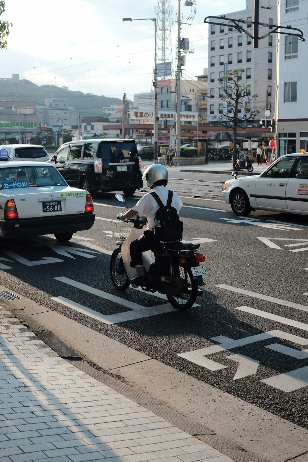 man in white shirt wearing helmet riding motorcycle