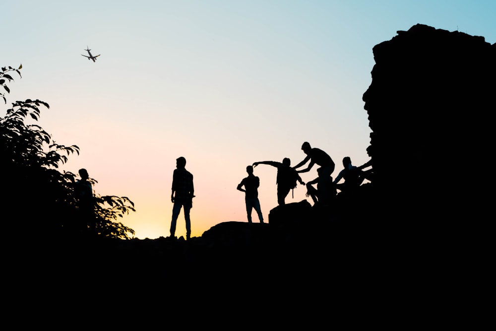 silhouette view of men on the hill