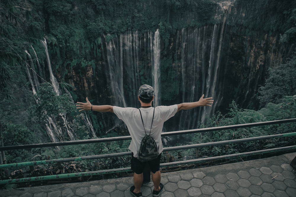 person standing near waterfalls