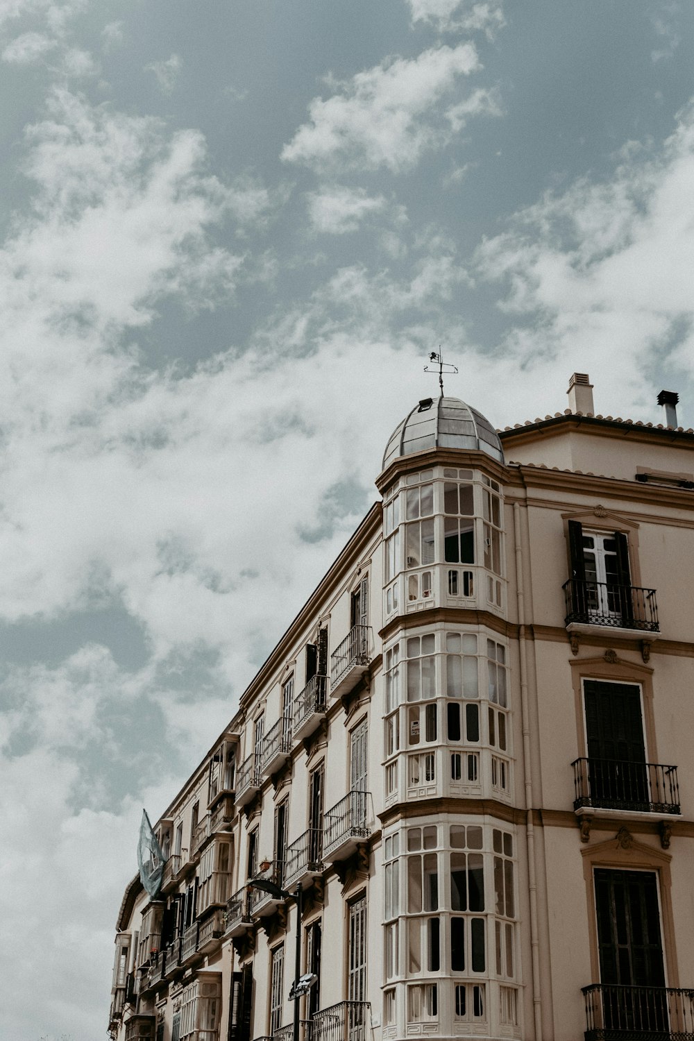 white concrete multi-storey building under a cloudy sky during daytime