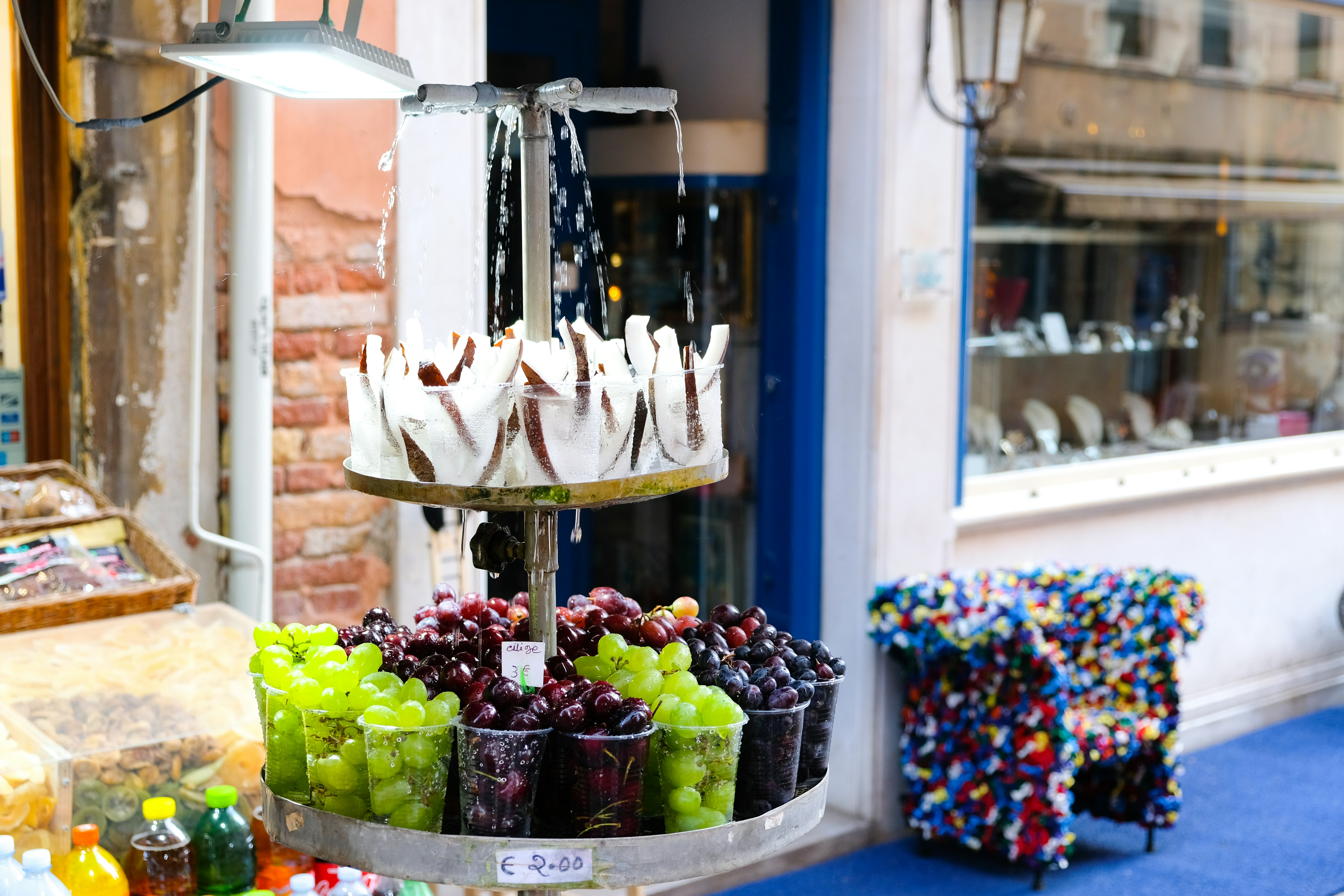 displayed fruits outside white and brown building during daytime