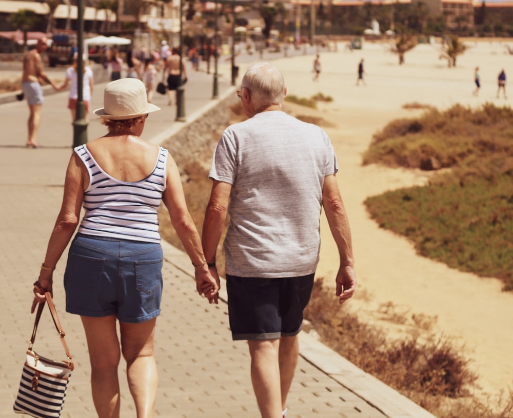 hombre y mujer caminando por el camino tomados de la mano