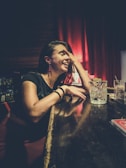 A charming woman laughing softly while seated at a chic lounge bar.