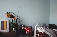 A minimalist bedroom corner showcasing a stackable shoe rack holding casual shoes.