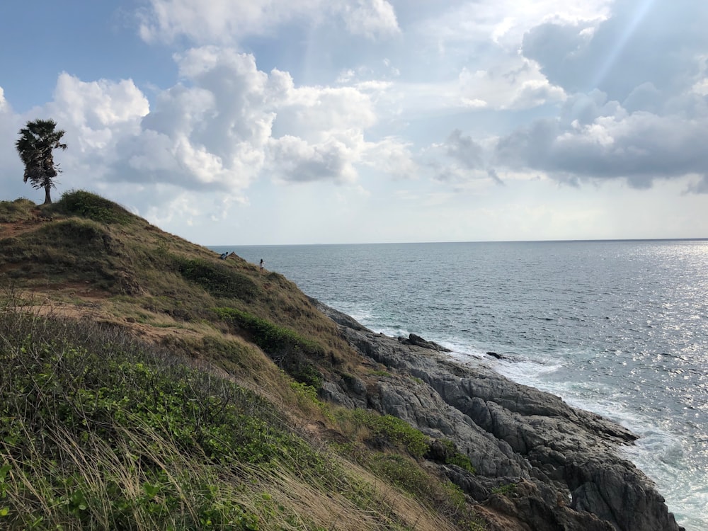 island facing ocean under cloudy sky