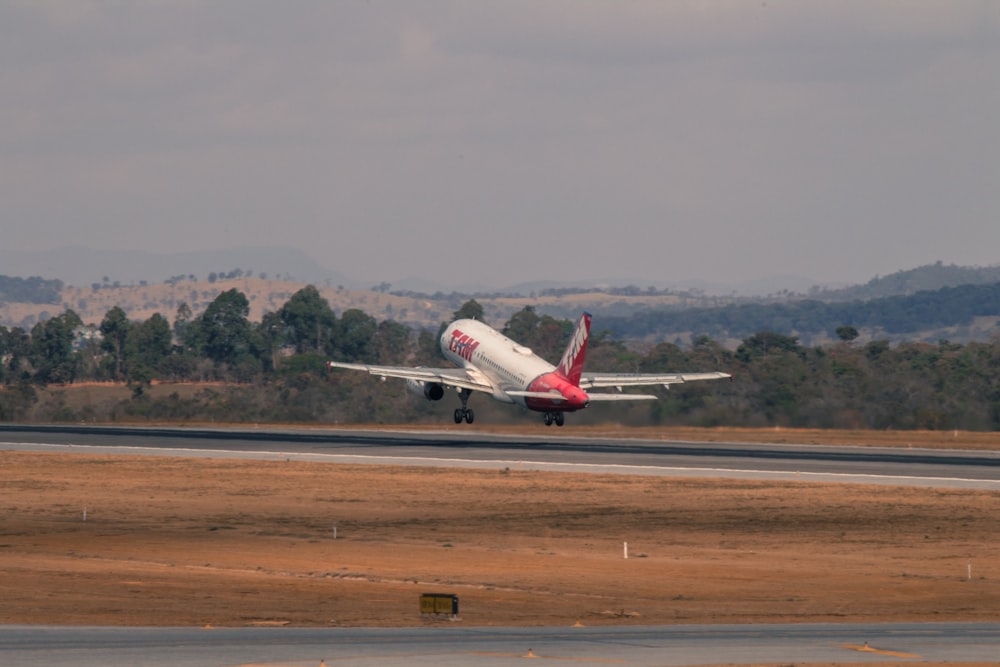avion blanc et rouge sur une piste