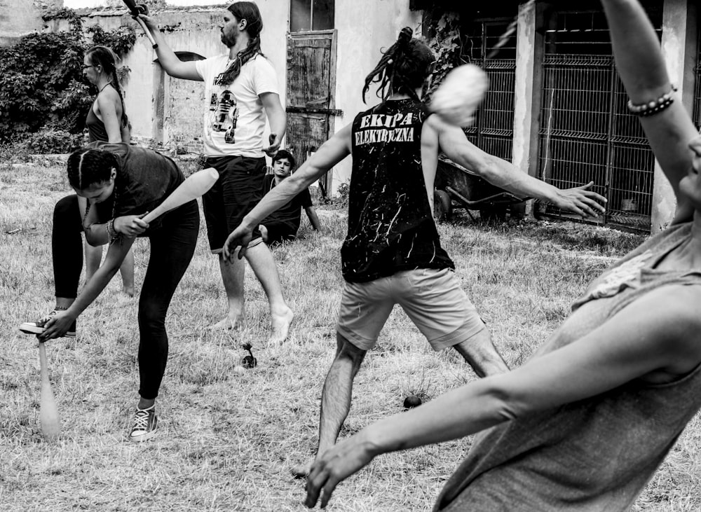 grayscale photography of men and women dancing in a field