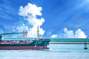 A large cargo ship sails through calm waters under a bright blue sky filled with fluffy white clouds. The ship is dark in color with visible structures like cranes and masts, suggesting it is equipped for transporting goods. In the background, a distant shoreline with a fence and poles can be seen.