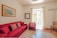 A cozy living room featuring a bright red door and colorful decor elements.