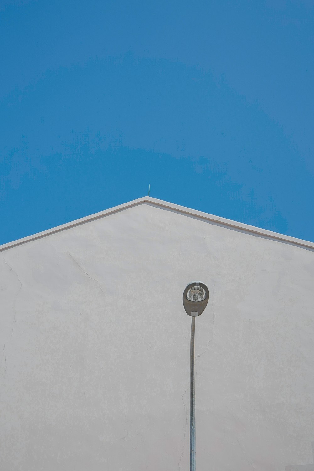 gray outdoor lamp post near white concrete building during daytime