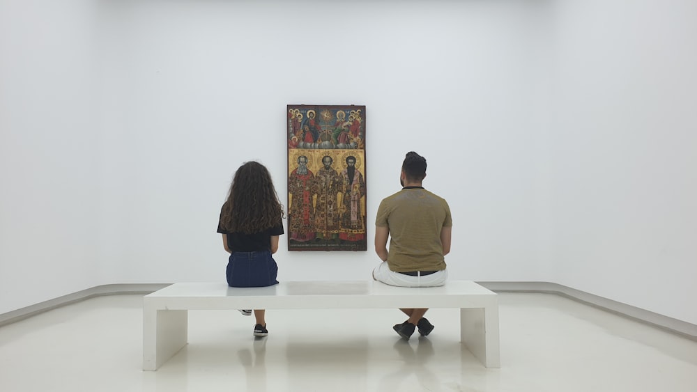 zwei Personen, die nebeneinander sitzen und Kunstwerke betrachten