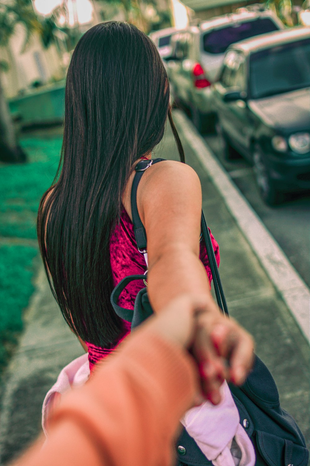 Mujer con vestido rosa y bolso de mano negro