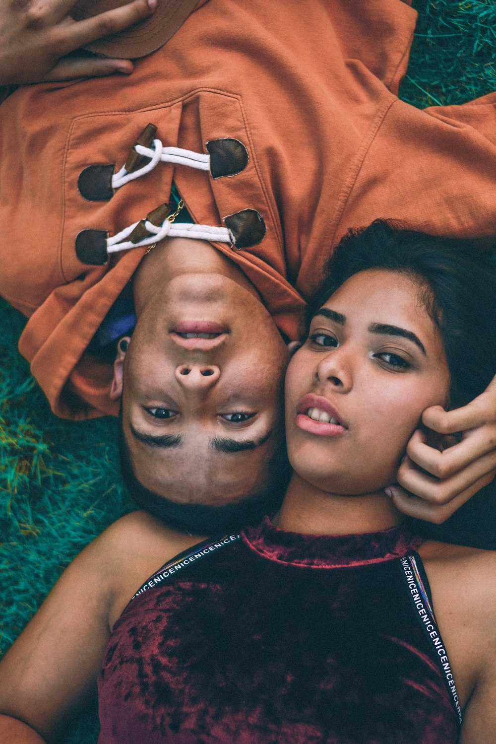 man and woman lying down in grass