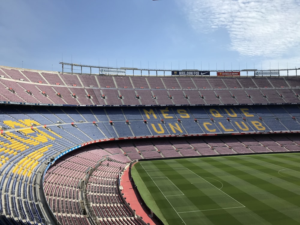 Estadio específico de fútbol sin gente bajo el cielo azul y blanco durante el día