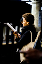 woman reading book while waiting in a train station