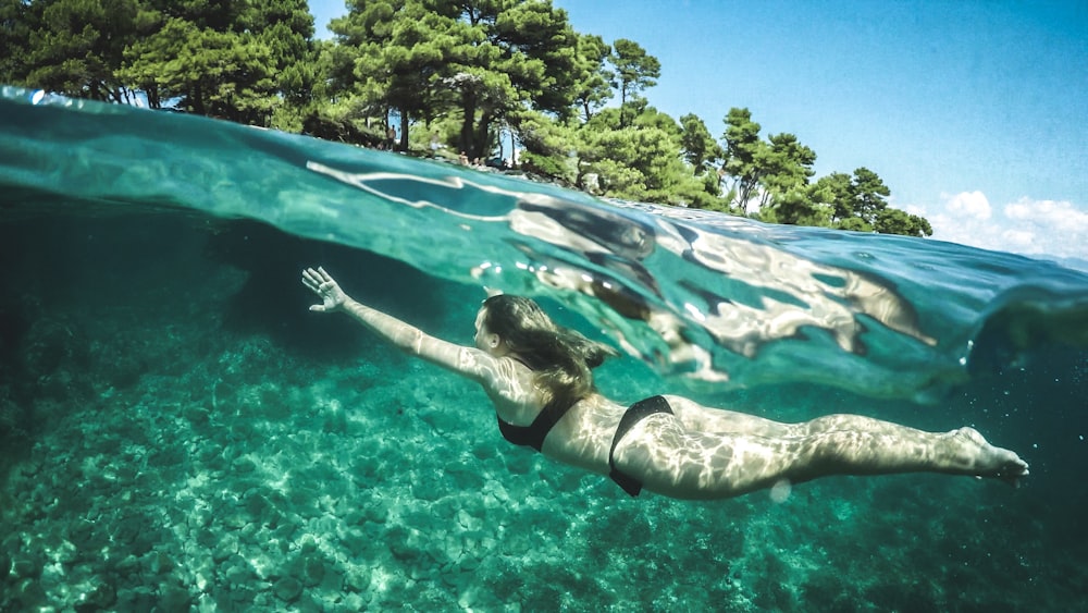 woman in black bikini swimming underwater