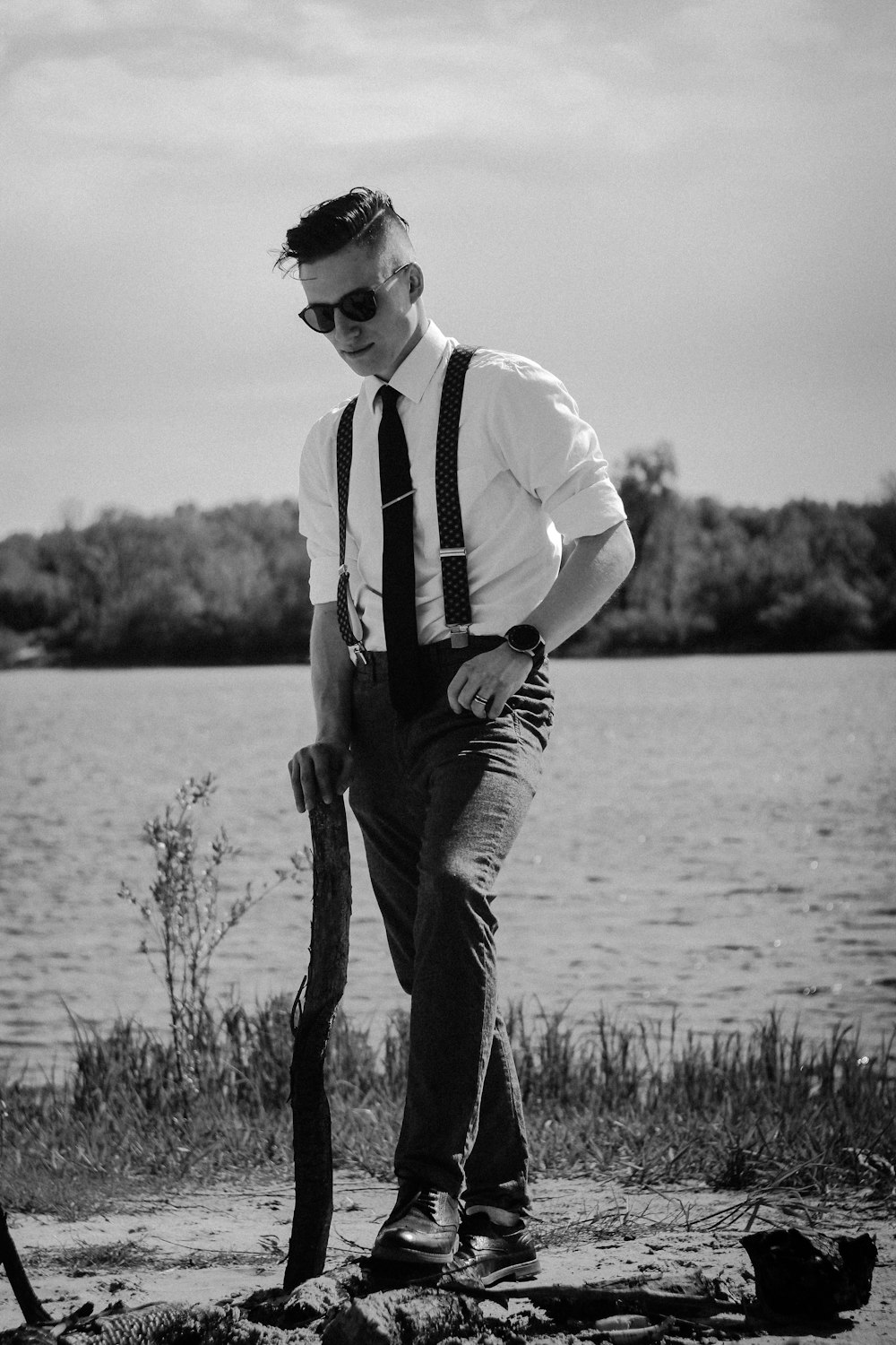 grayscale photo of man near body of water