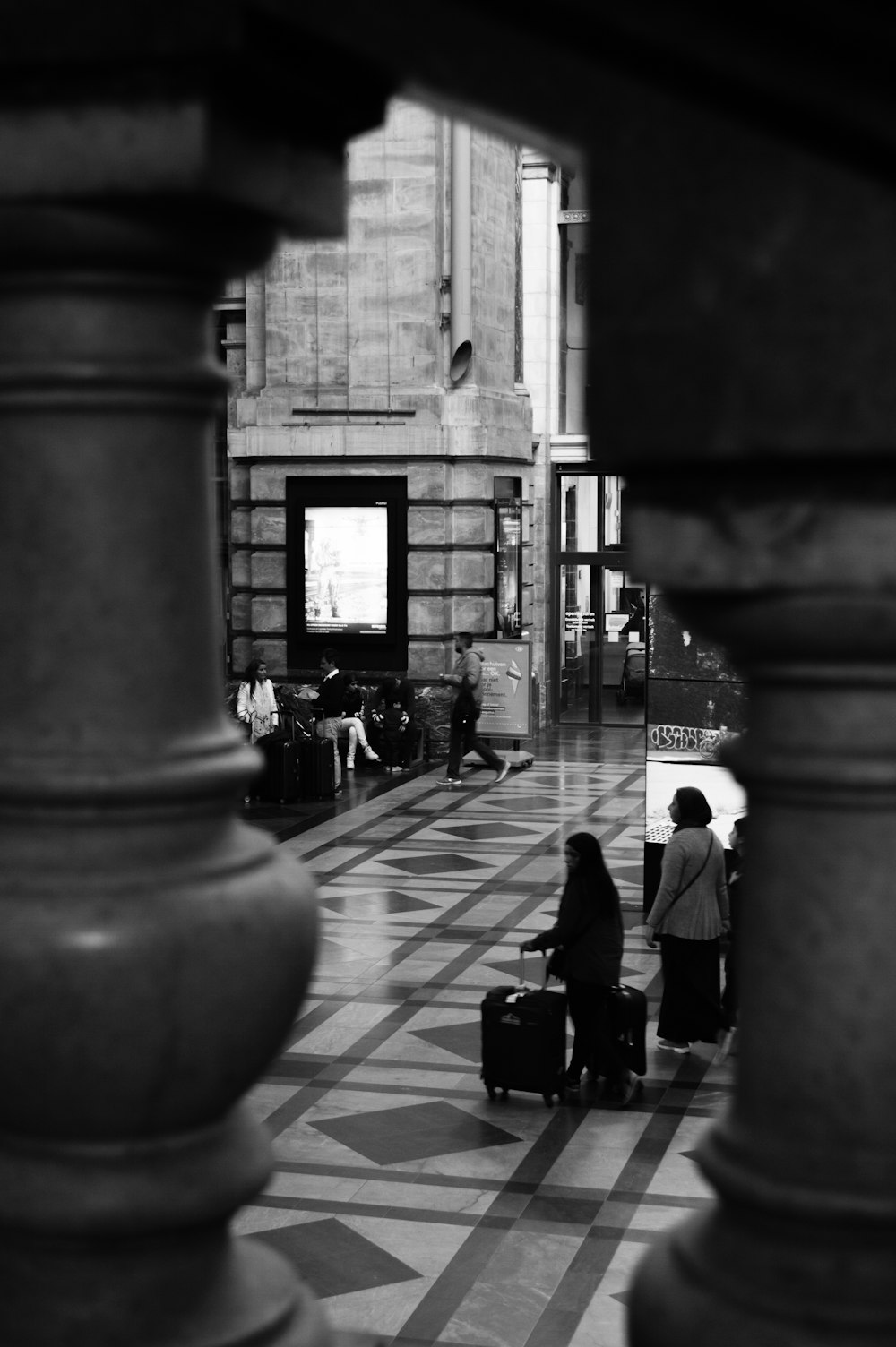 a black and white photo of people with luggage