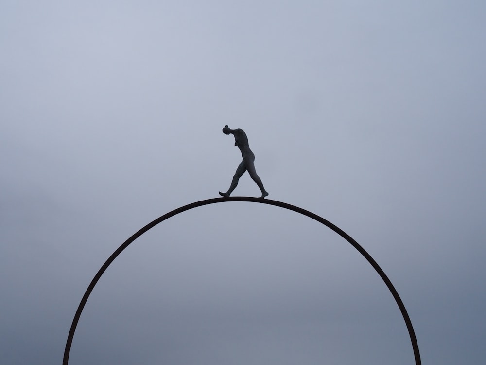 man walking on hola hoop statue