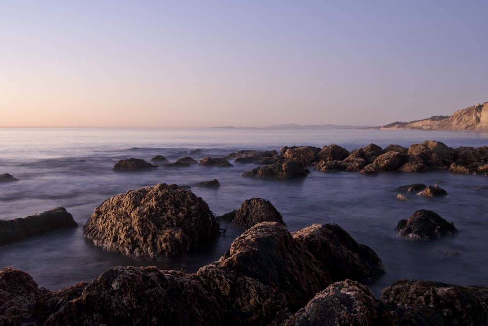 large black rocks surrounded by water