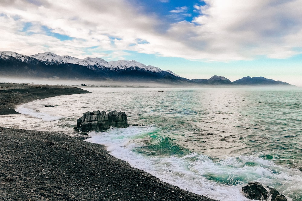 rocky and dirt seashore during day