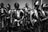 A group of suits of medieval armor stands in a display, each featuring intricate metalwork and detailed fittings typical of knight armor from the Middle Ages.