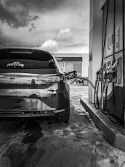A modern hydrogen refueling station with a sleek car filling up under a clear blue sky.