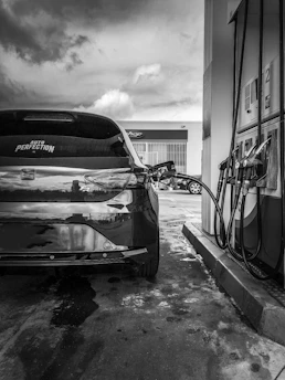 A modern hydrogen refueling station with a sleek car filling up under a clear blue sky.