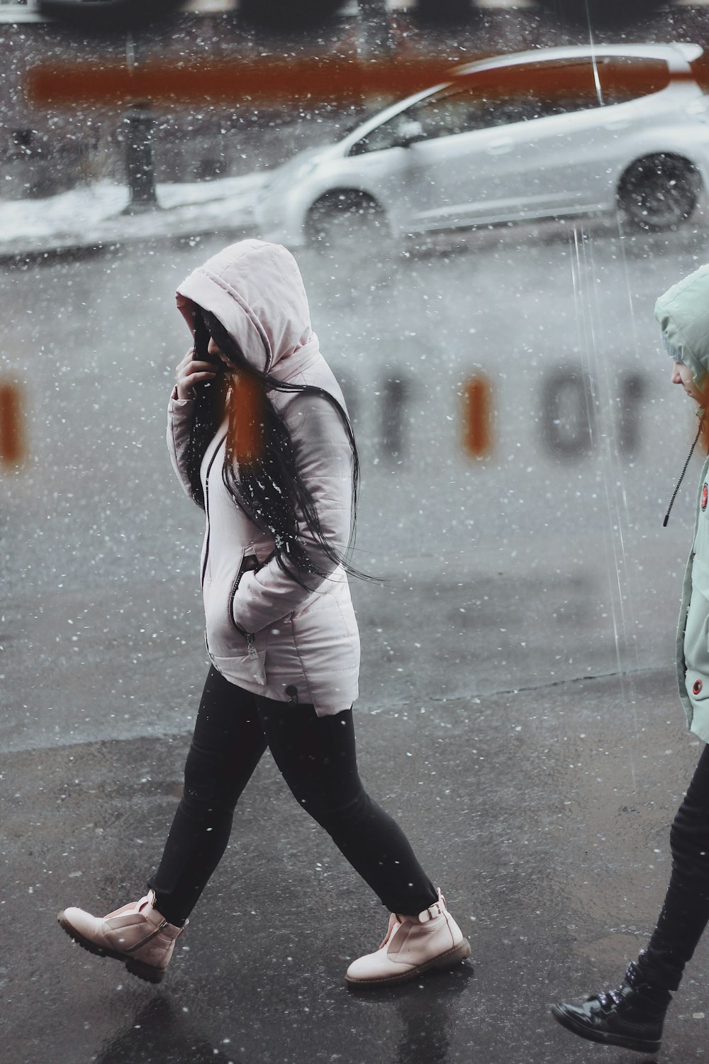 woman wearing white zip-up hoodie walking on road