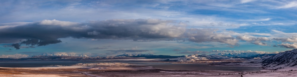 a snow covered mountain with a body of water in the distance