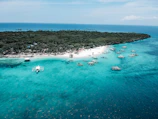 Pristine turquoise waters and white sandy beaches of West Nusa Tenggara with traditional boats anchored near shore.