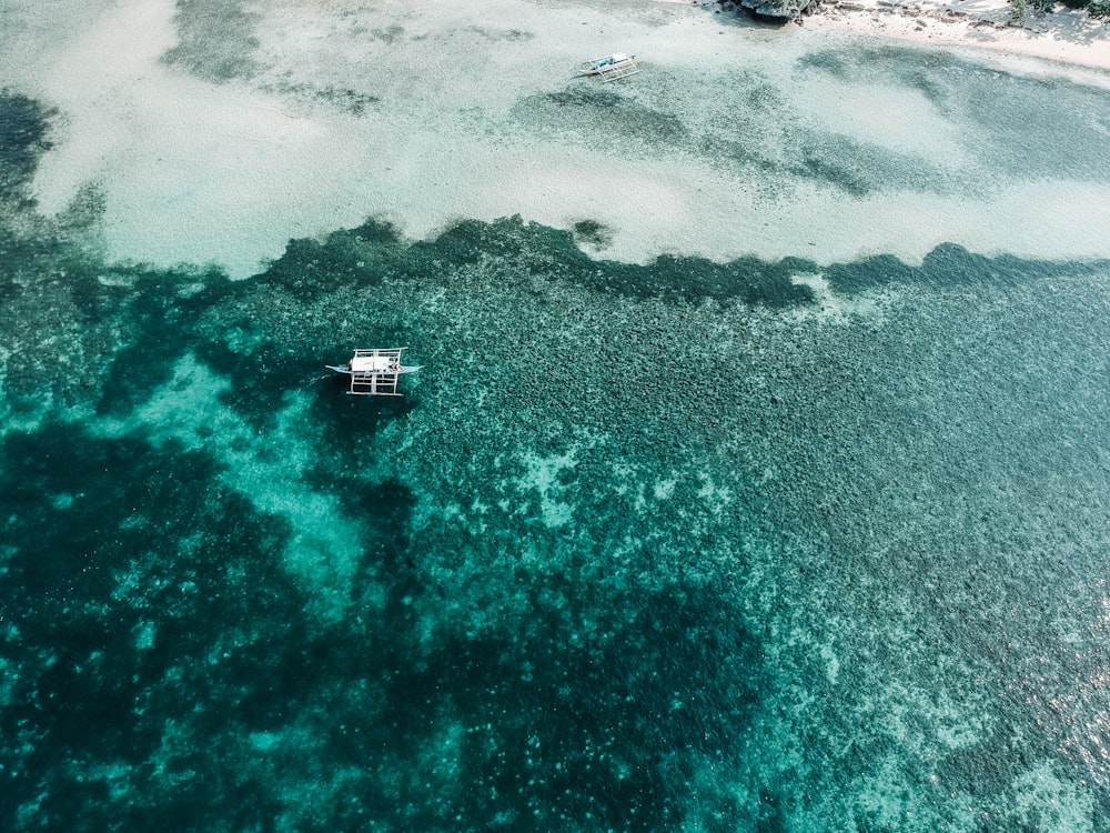 fotografia aerea di barca bianca sullo specchio d'acqua durante il giorno