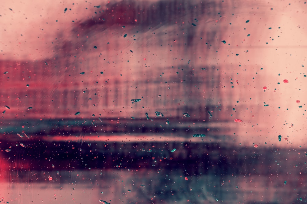 a window with rain drops on it and a building in the background