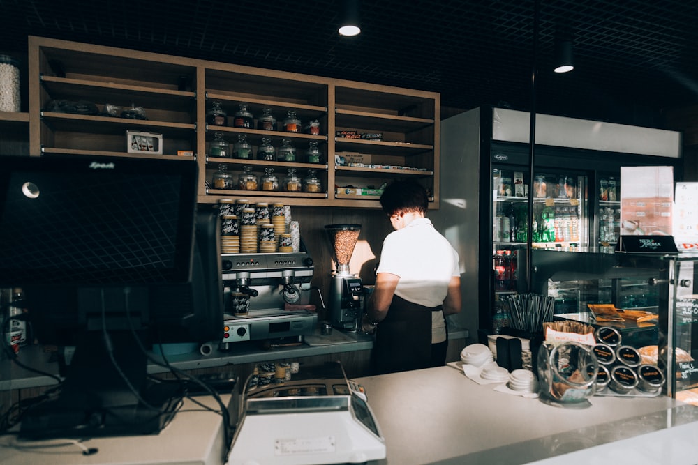 femme portant un haut blanc derrière le comptoir