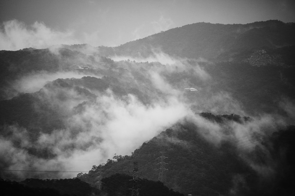 Graustufenfotografie von Bergen mit Wolken