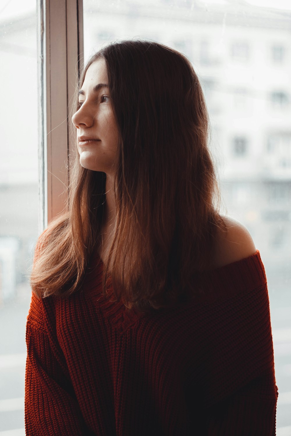 woman beside glass looking to her right