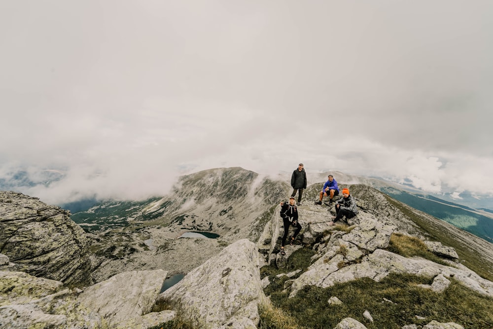 four people hiking on mountain during daytime