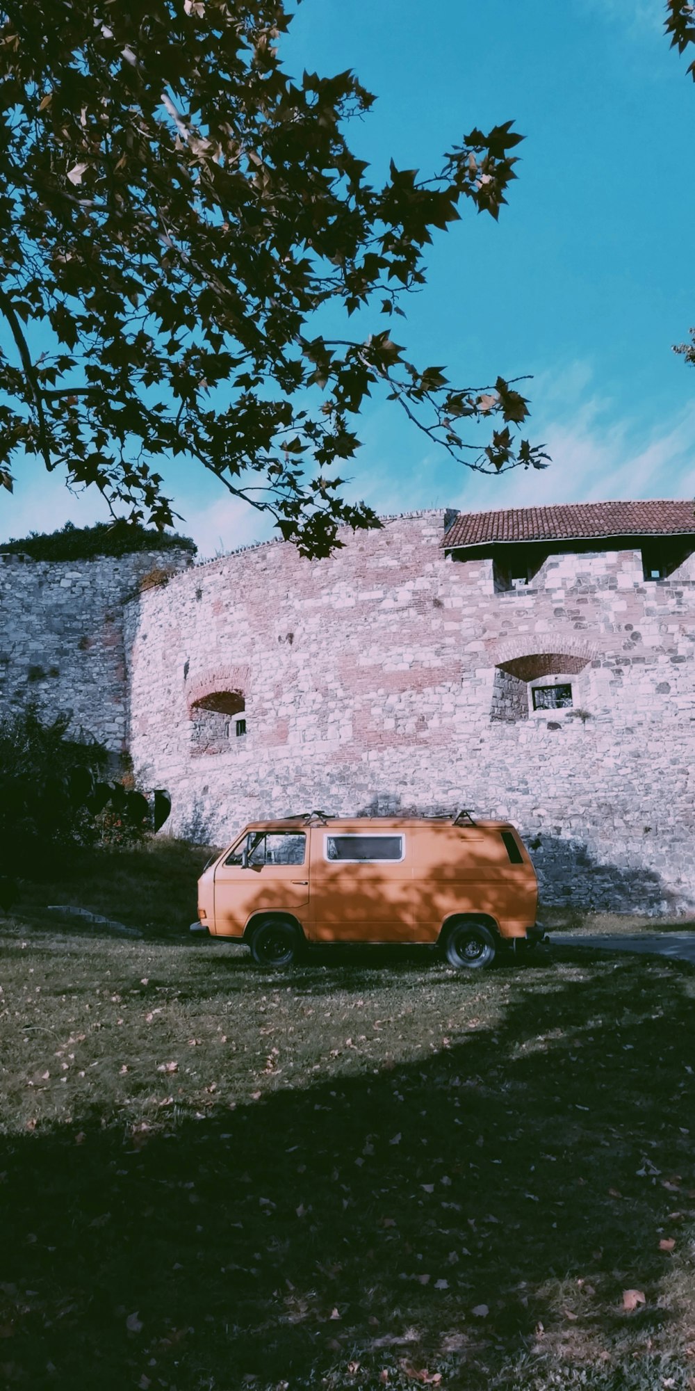 brown van parked beside wall