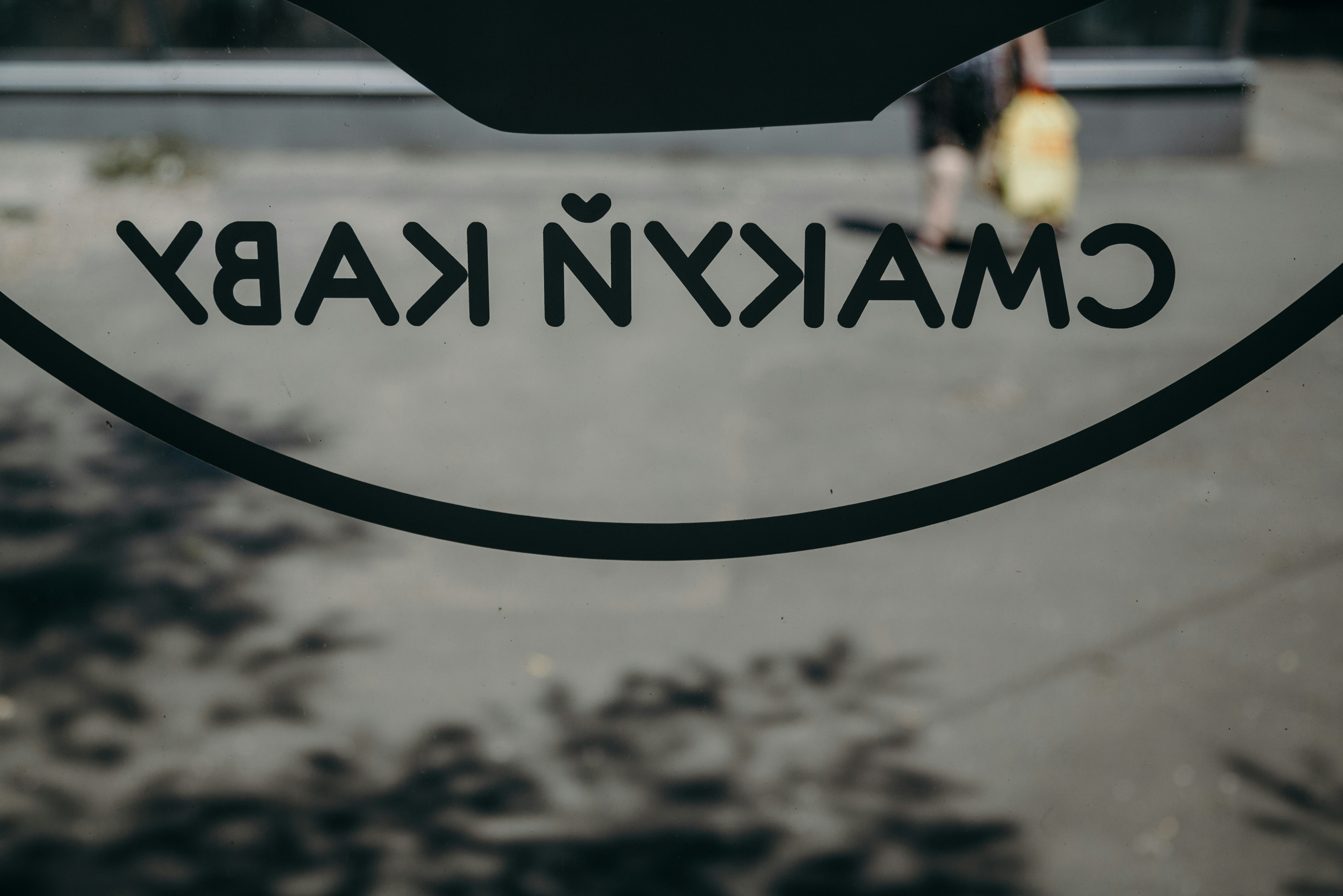 a close up of a sign with a person walking in the background