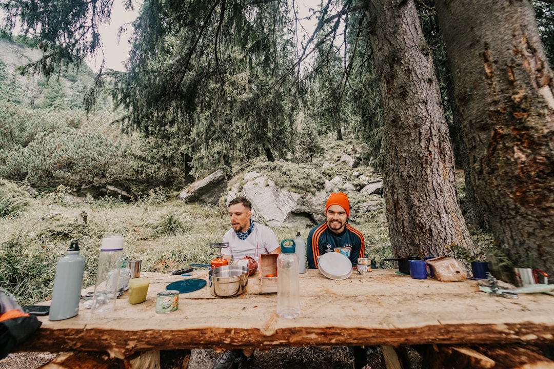 two persons sitting in front of stump table