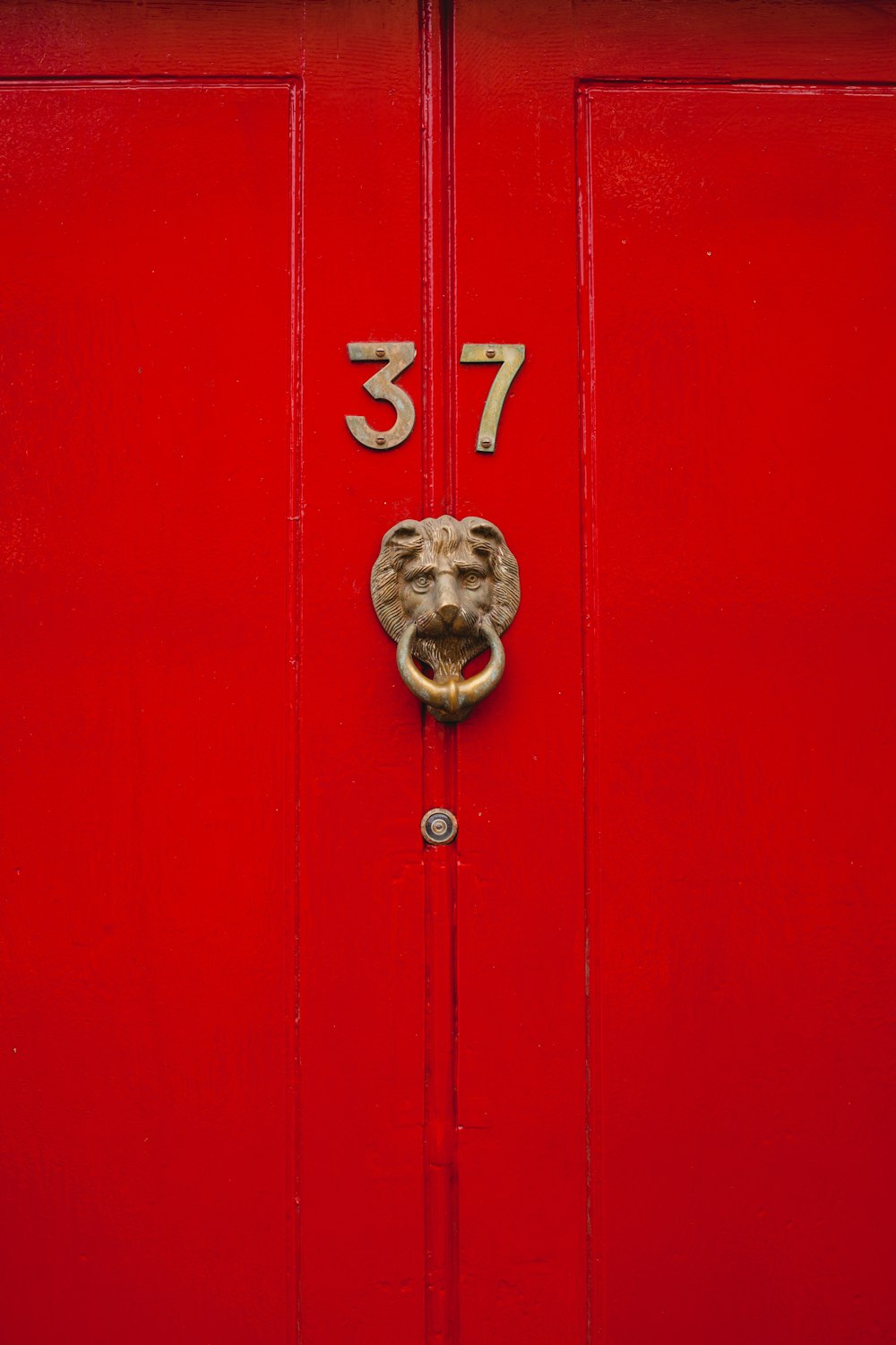 Puerta de madera roja con el número 37