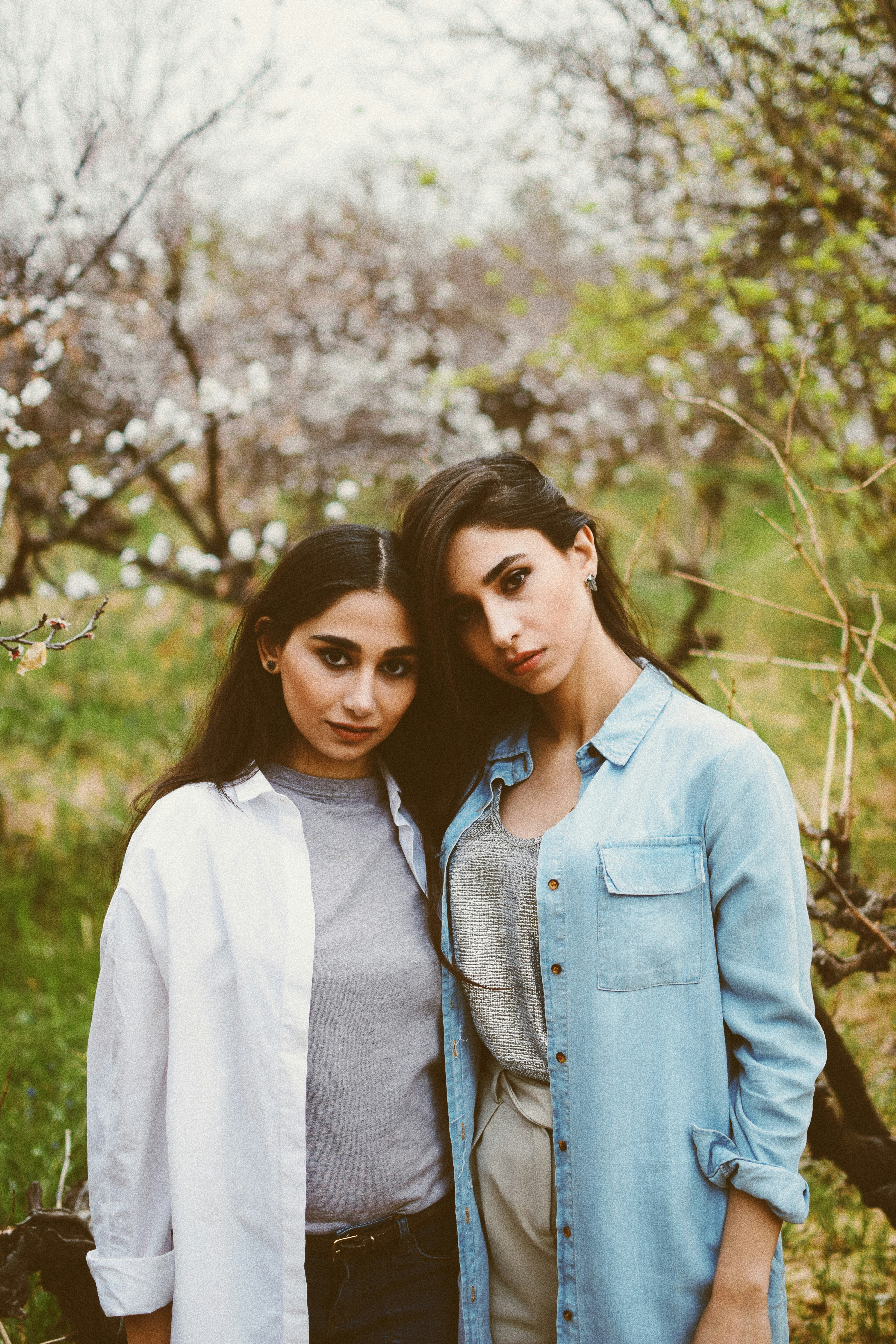 woman wearing blue denim jacket standing near another woman during daytime