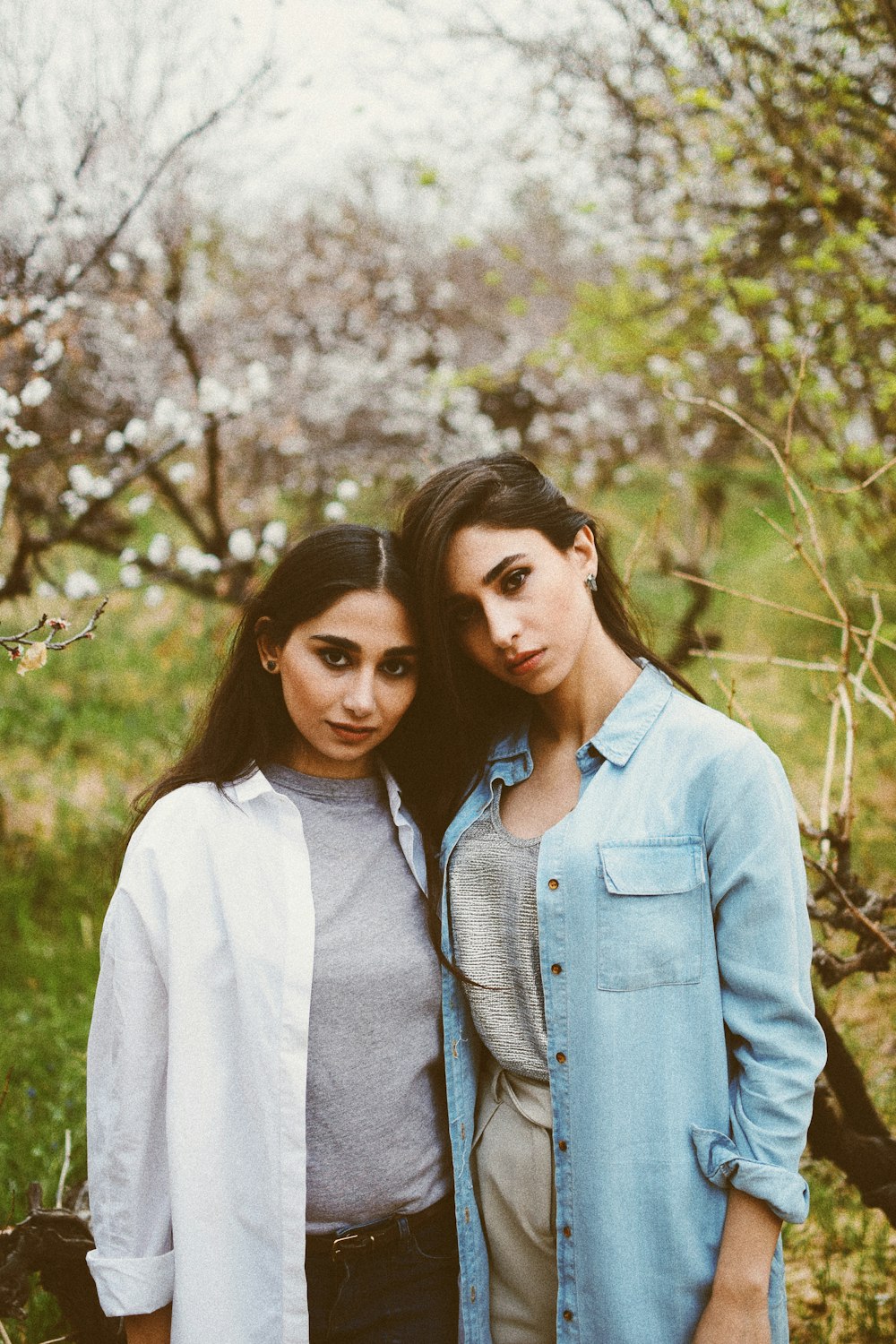 woman wearing blue denim jacket standing near another woman during daytime